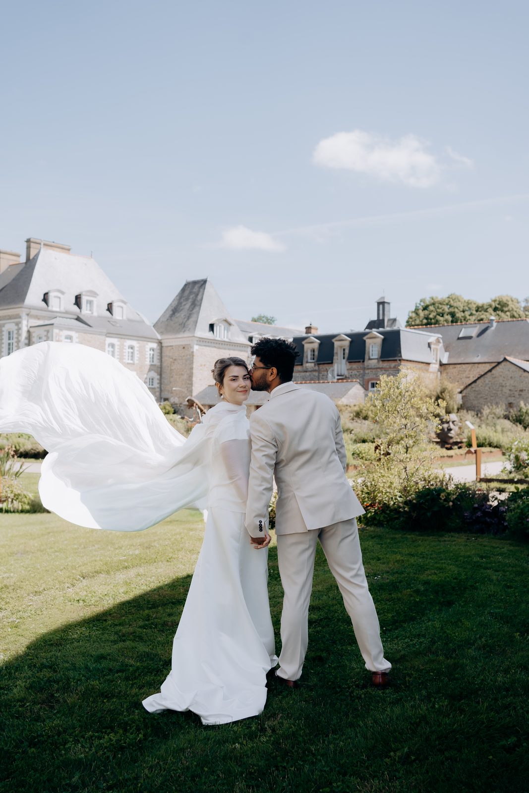 Le voile de la mariée dans le vent devant le château