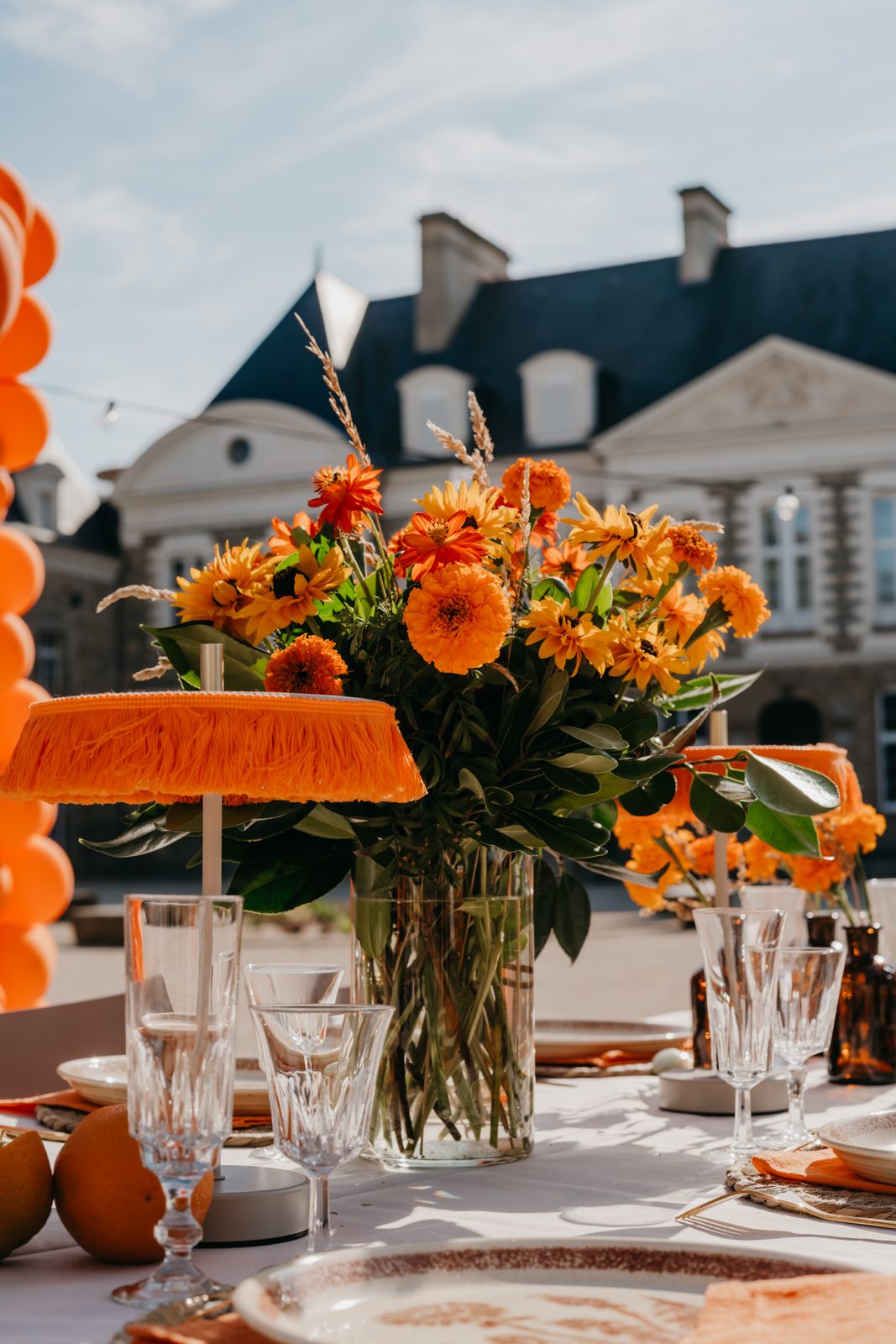 Centre de table fleuri aux tons orangés devant le château